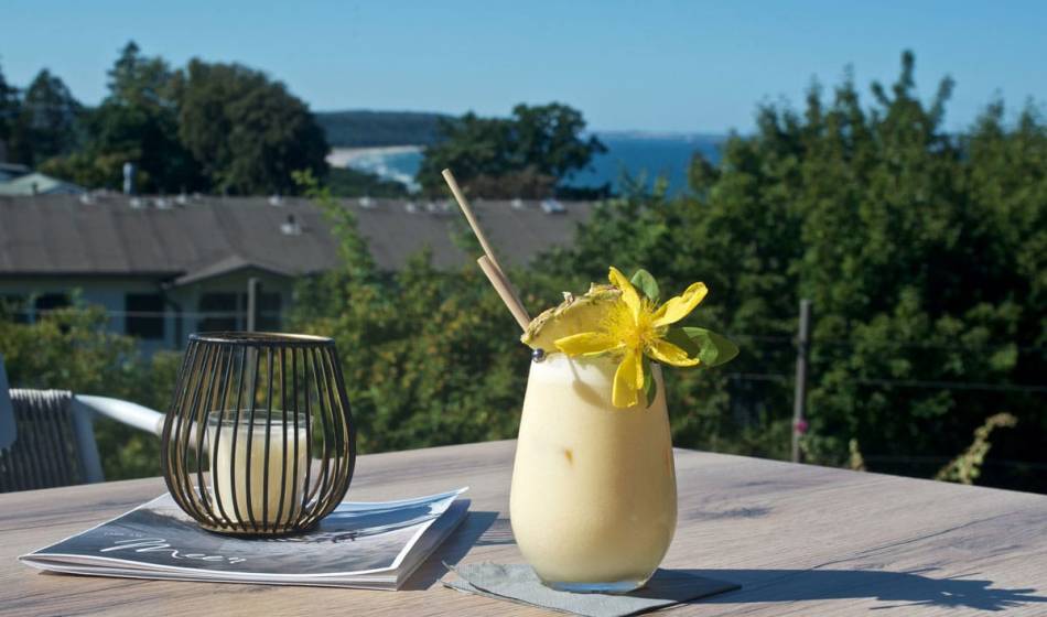 Ein Cocktail mit exotischer Blüte auf der Seeblick-Terrasse des Vju Hotels auf Rügen.