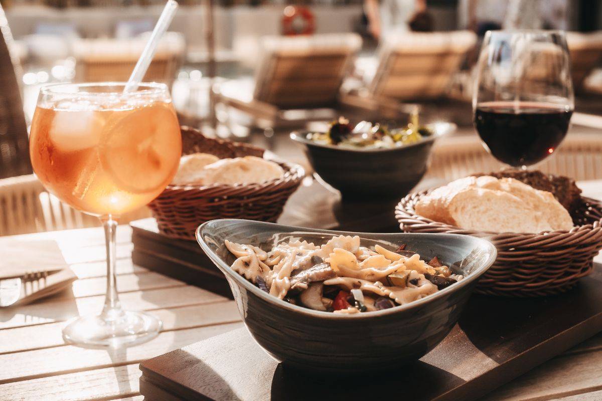 Verschiedene Tapas mit Brot, Wein und Aperitif auf gedecktem Tisch bei der Spanish Tapas Night im Barefoot Hotel Mallorca.