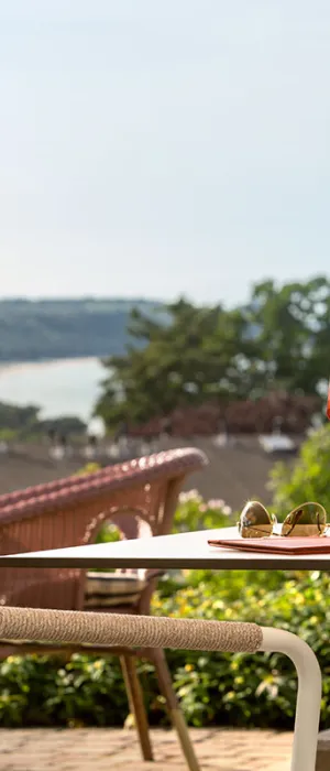 Sunny hotel terrace at Vju Hotel Rügen with sea view and two Aperol Spritz – perfect for the All-Inclusive Summer Special!