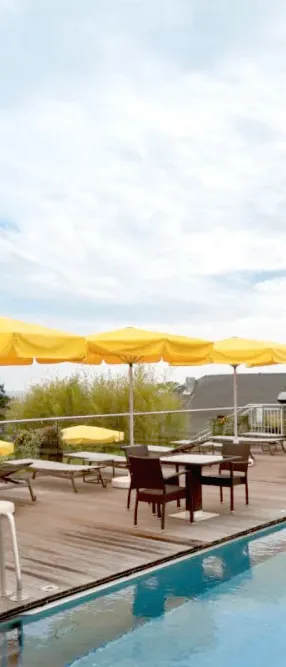 Pool terrace with parasols and a view of the Heringsdorf pier for the perfect summer vacation at the Hotel Kaiserhof.