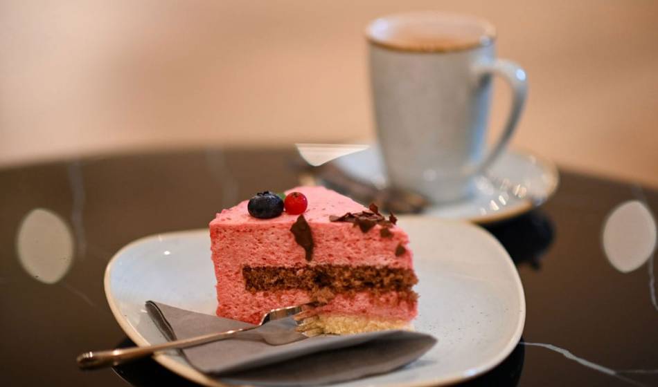 Köstlicher Kuchen mit frischen Beeren und eine Tasse Kaffee in der gemütlichen Lounge Wohnzimmer des Vju Hotels auf Rügen.