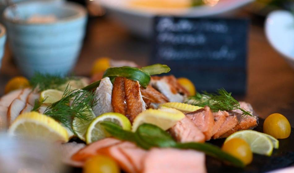 Auswahl an geräuchertem und frischem Fisch am Frühstücksbüffett im Vju Hotel Rügen mit Zitronen und Dill.