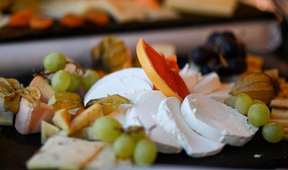 Auswahl an Käsesorten beim Frühstück im Vju Hotel Rügen, serviert mit Trauben und Grapefruit in Ihrem Genussurlaub.