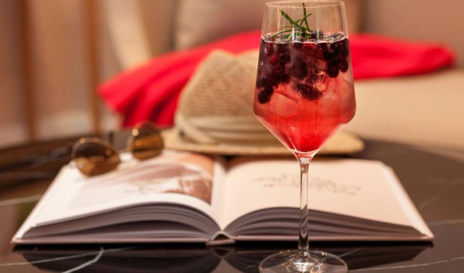 Fruchtiger Cocktail mit Rosmarinzweig, serviert in der Lounge Wohnzimmer für Urlaubsfeeling im Vju Hotel auf Rügen.