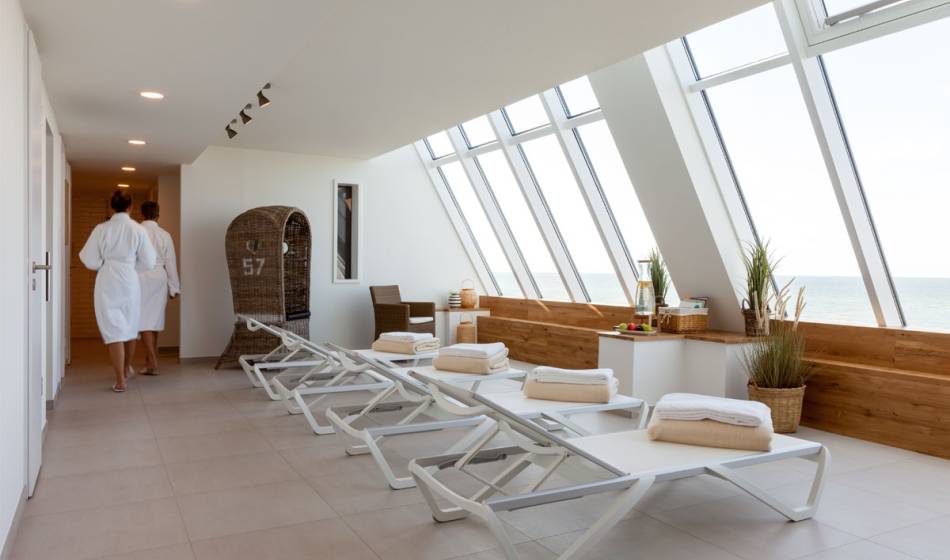 Relaxation room in the spa at the Wyn. Strandhotel on Sylt with loungers, natural decoration and panoramic views of the sea