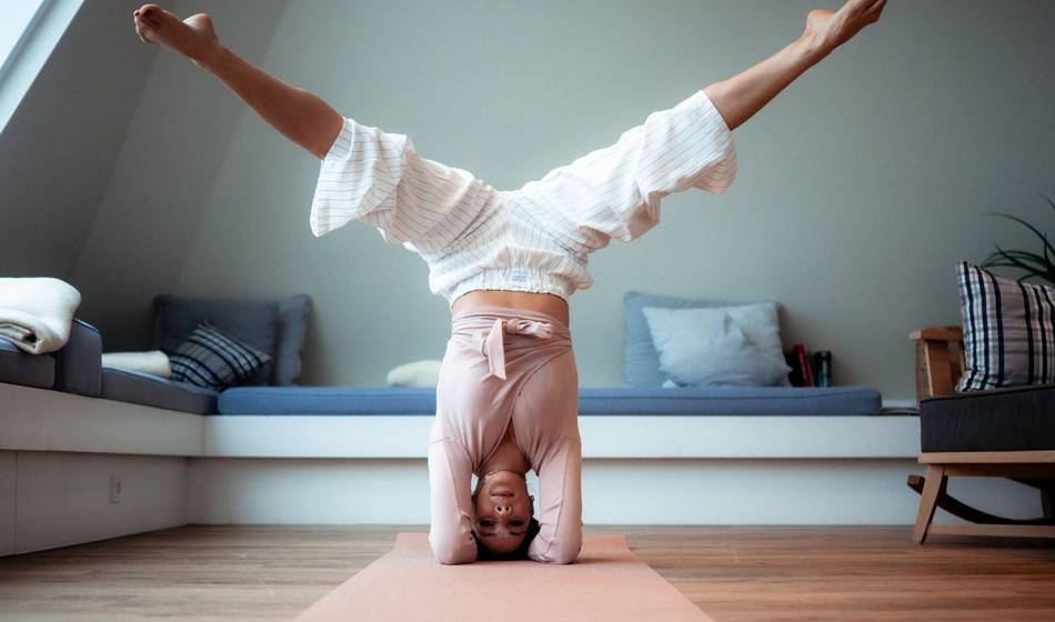 Personal-Trainerin Halima Elkasmi macht einen Kopfstand auf einer Yogamatte im stilvollen Wyn. Strandhotel auf Sylt.