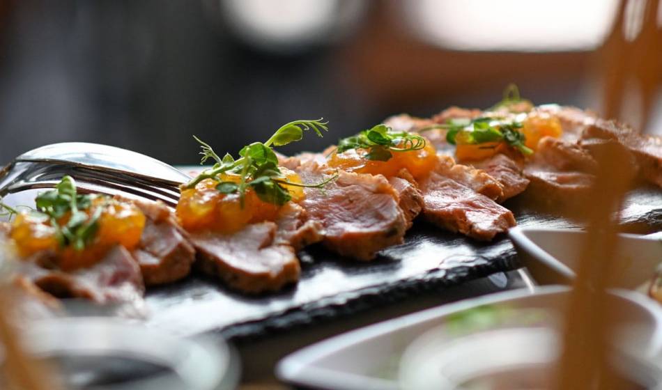 Auswahl an Wurstspezialitäten am Früchstücksbüffett im Vju Hotel auf Rügen, angerichtet mit Kräutern und feiner Garnitur.