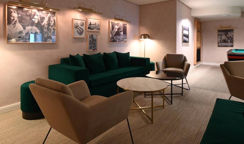 Eleganter Lounge-Bereich im Vju Hotel auf Rügen mit bequemen Sitzmöbeln und dekorativer Wandgestaltung für entspannte Pausen.