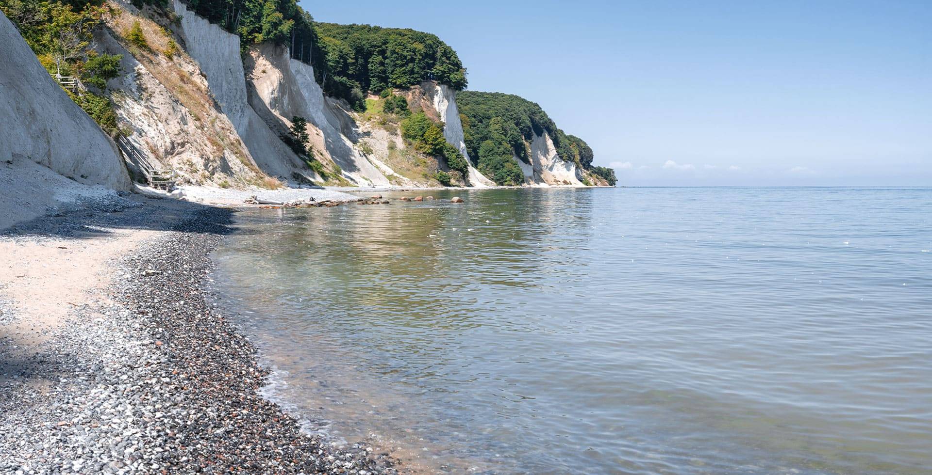 Kreidefelsen auf Rügen mit ruhigem Meer und klarem Himmel.