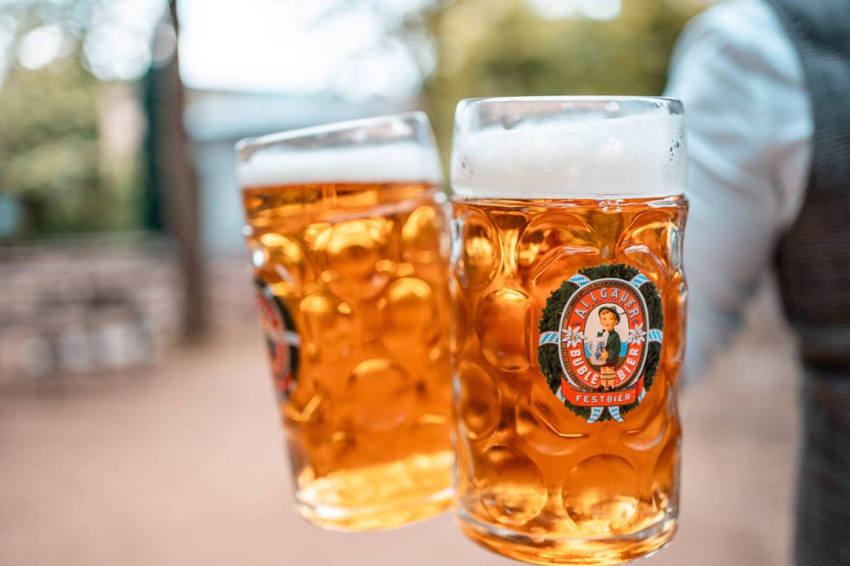 Zwei Maß mit Biergefüllt werden direkt in die Kamera gehalten