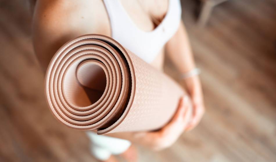 Cristina Schubert Pastor trägt eine Yogamatte beim Gesundheitsevent im Wyn. Strandhotel Sylt, direkt am Meer.