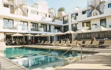 Look out over the Barefoot Hotel in Mallorca, surrounded by sun loungers, parasols and a refreshing pool.