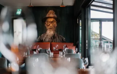 Stylishly decorated interior of the #herrhoshi restaurant with portrait painting in the Hotel Künstlerquartier Seezeichen in Ahrenshoop.
