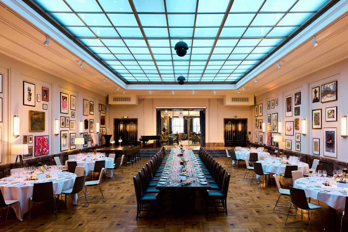 Festlich eingedeckter Lichtsaal mit langen Tafeln und Glaskuppel für das Event Wallners Lieblinge im Hotel Elephant Weimar.