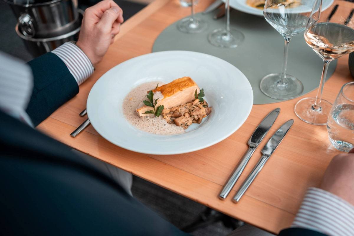 Eleganter gedeckter Tisch mit Fischgericht und Weingläsern beim Wine & Dine Event in der Historischen Mühle in Potsdam.