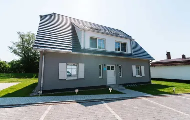 Strandvilla Seezeichen in Ahrenshoop with white shutters, large roof and well-kept garden.