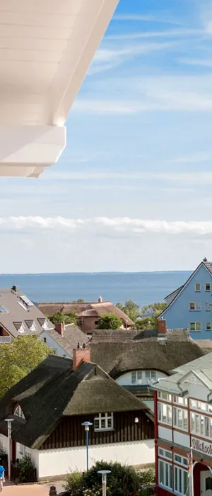 View from Koopmanns Hotel over colorful houses and thatched roofs to the Baltic Sea during the Summer Special