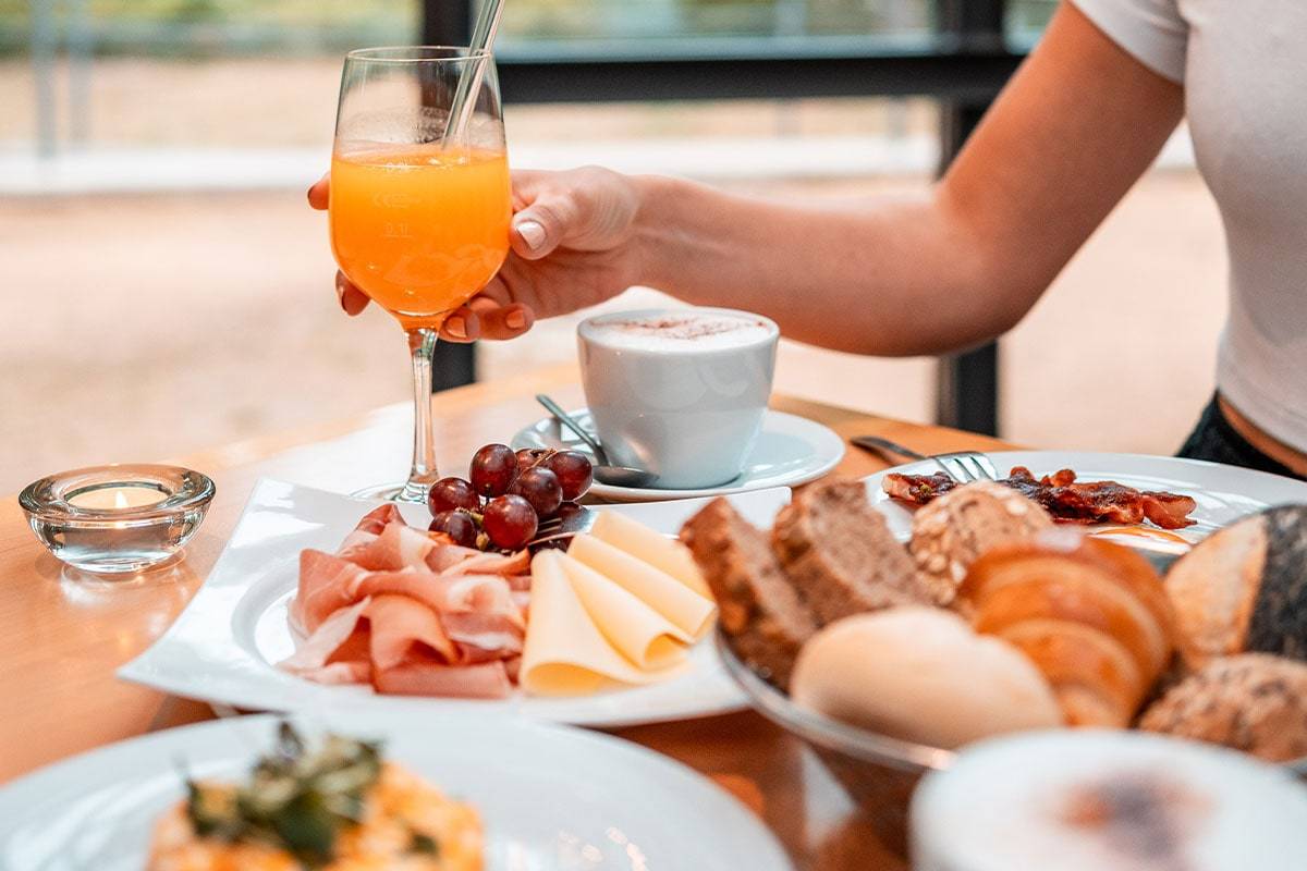 Nahaufnahme von reich gedecktem Brunch-Tisch mit Orangensaft und Heißgetränk beim Osterbrunch in der Historischen Mühle in Potdam.