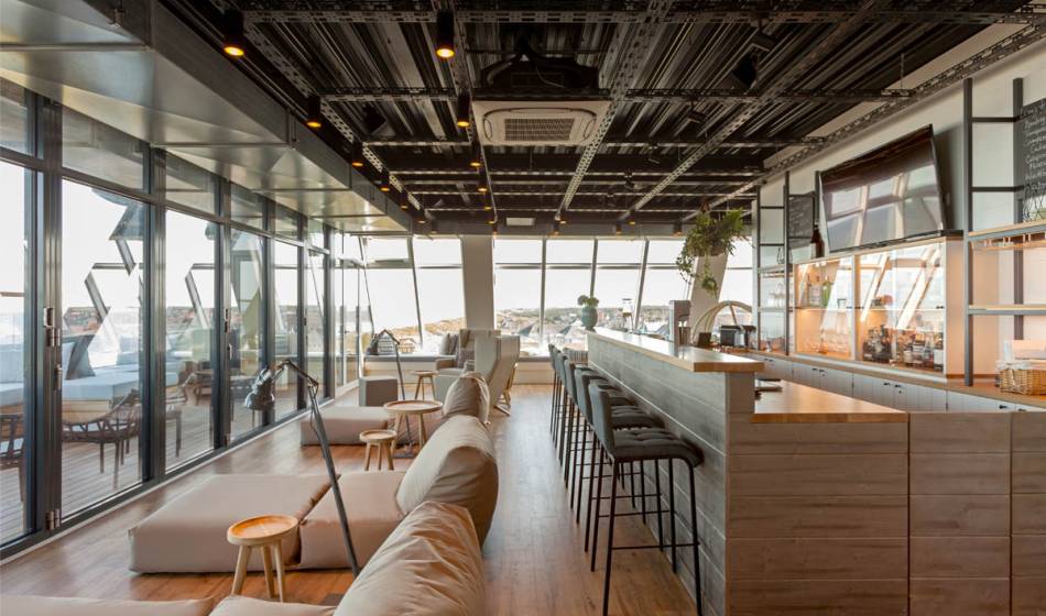 Bar and lounge area in the Wyn. Strandhotel on Sylt with modern furnishings and large glass fronts.