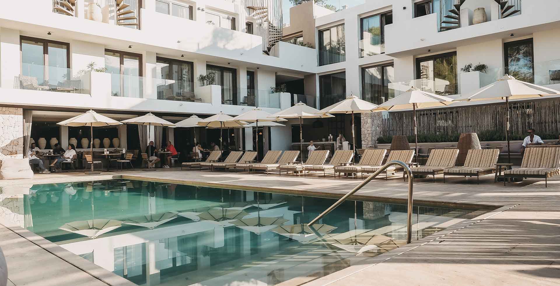 Poolbereich mit Liegen, Sonnenschirmen und Blick auf das Barefoot Hotel mit tollen Angeboten für deinen Urlaub auf Mallorca.