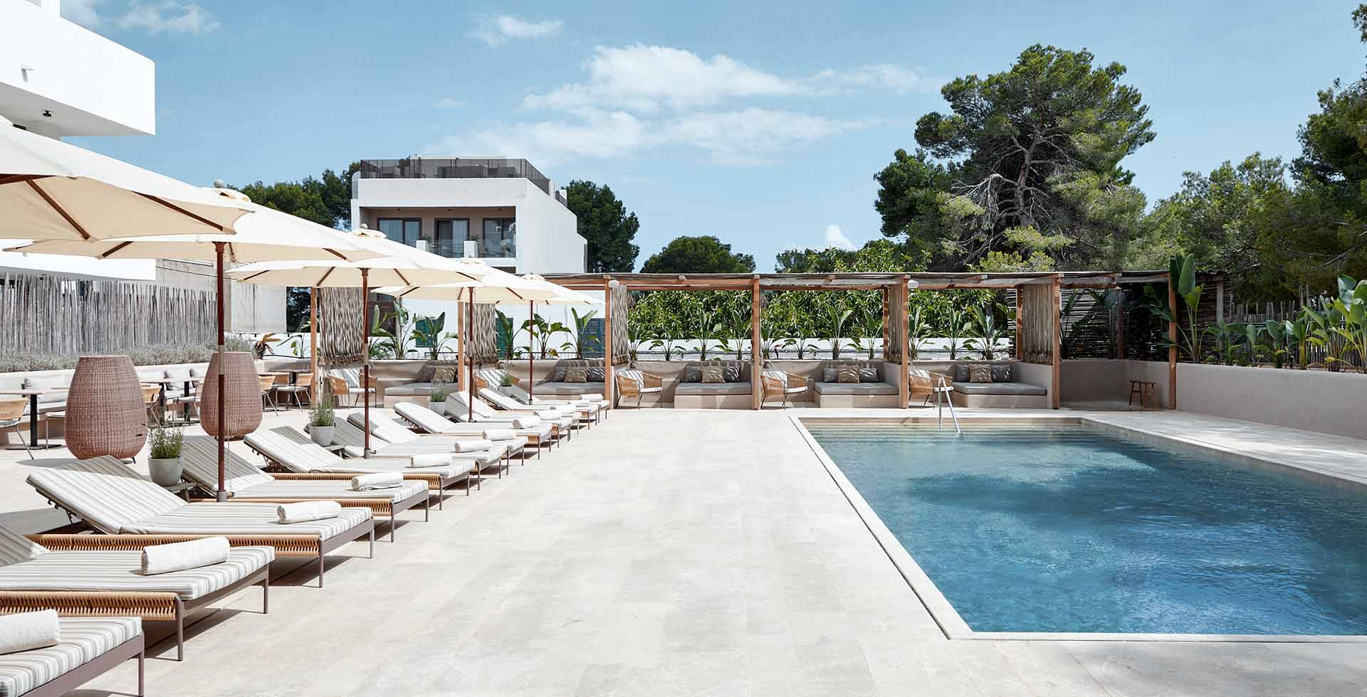 Moderner Poolbereich mit weißen Sonnenschirmen und gemütlichen Liegen im Frühbucher-Angebot