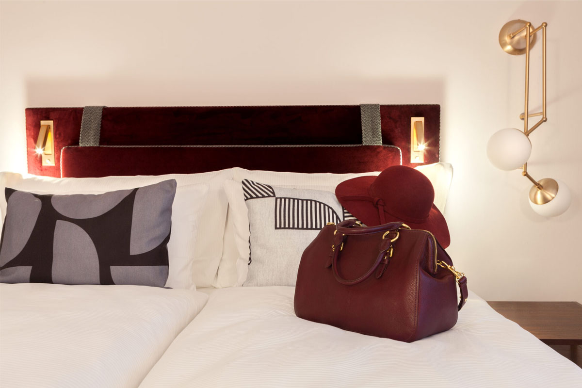 Elegant room with red headboard and decoration in the Hotel Elephant Weimar for a summer vacation.