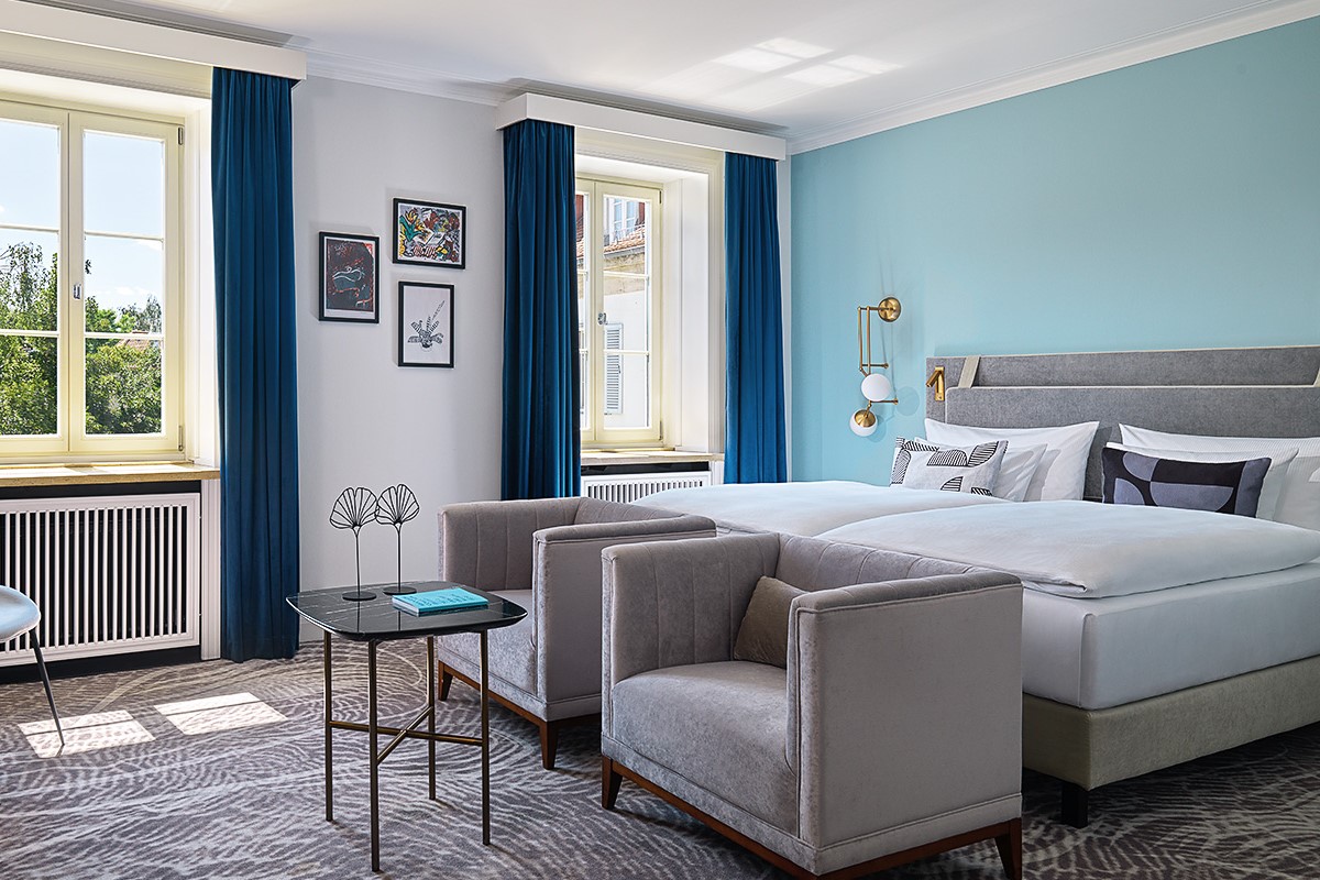 Bright and modern hotel room at the Hotel Elephant Weimar with stylish furnishings and large windows with a view.