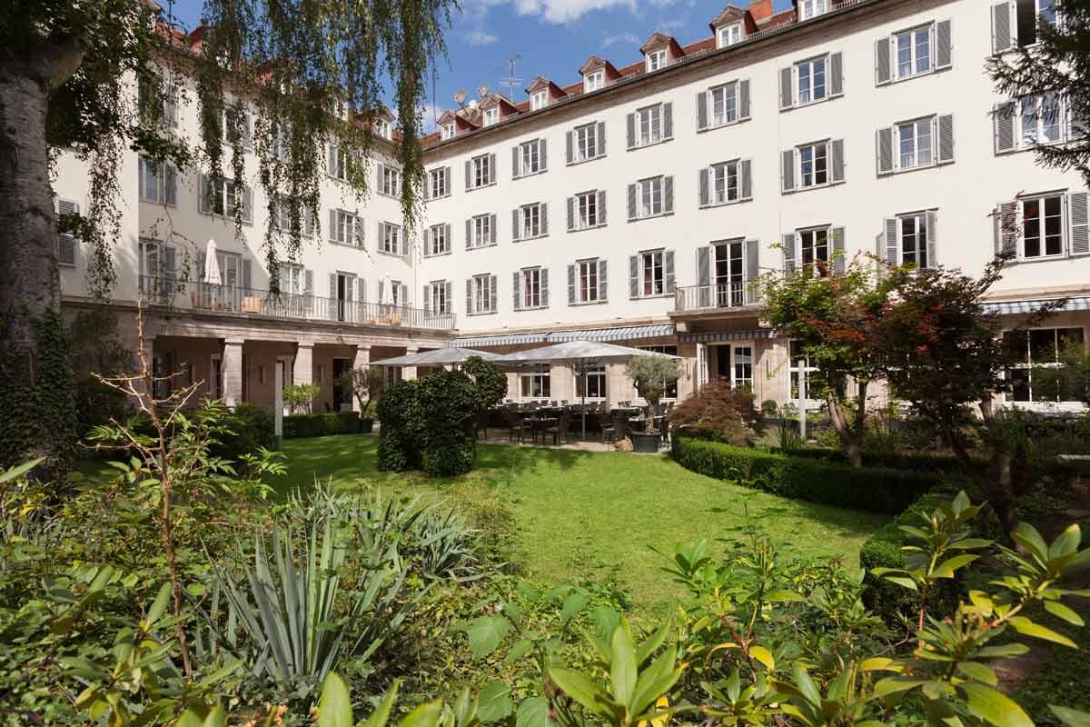 Exterior view of the Hotel Elephant Weimar with a view of the well-tended garden and the elegant windows of the building.