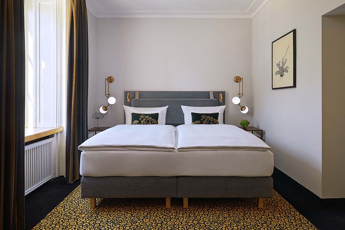 Luxurious bed in the Lyonel Feininger Suite with tasteful furnishings and inviting atmosphere in the Hotel Elephant.