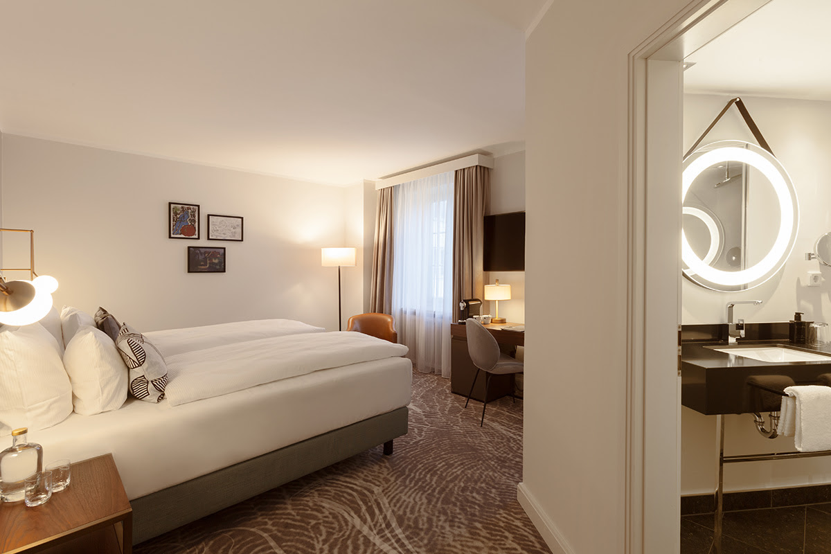 Deluxe room at the Hotel Elephant Weimar with modern design, a large bed and private bathroom.