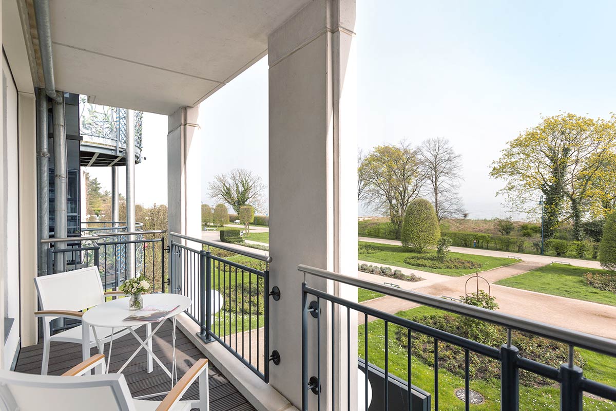 Balkon im Hotel Kaiserhof Heringsdorf mit Sitzmöbeln und Blick auf Park und Strand