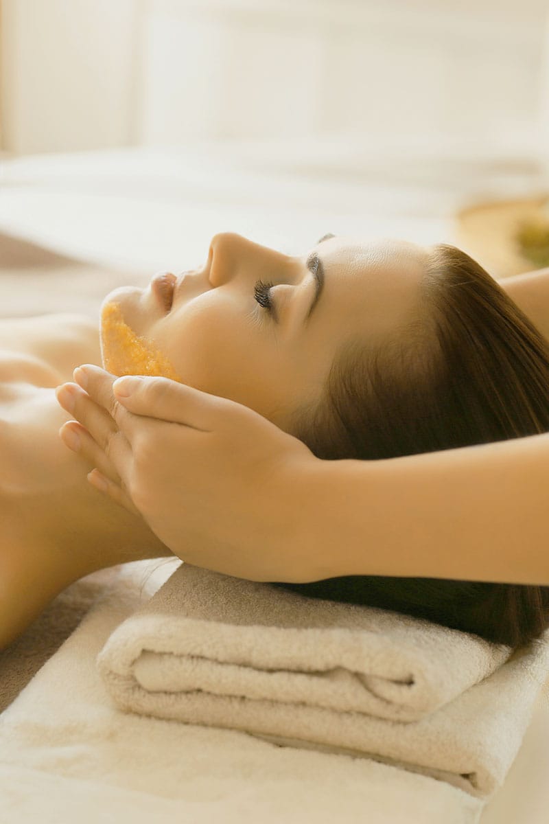 Frau entspannt bei einer Gesichtsmassage mit Bernsteinöl im Wellnessurlaub im Hotel Kaiserhof Heringsdorf.