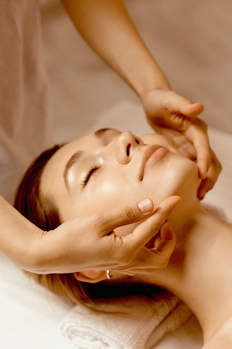 Frau genießt eine entspannende Gesichtsmassage mit sanften Handbewegungen beim Wellness im Hotel Kaiserhof Heringsdorf.