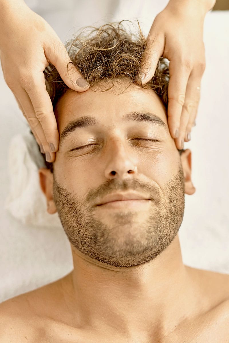 Mann genießt eine entspannende Kopfmassage während einer Kosmetikbehandlung im Hotel Kaiserhof Heringsdorf.
