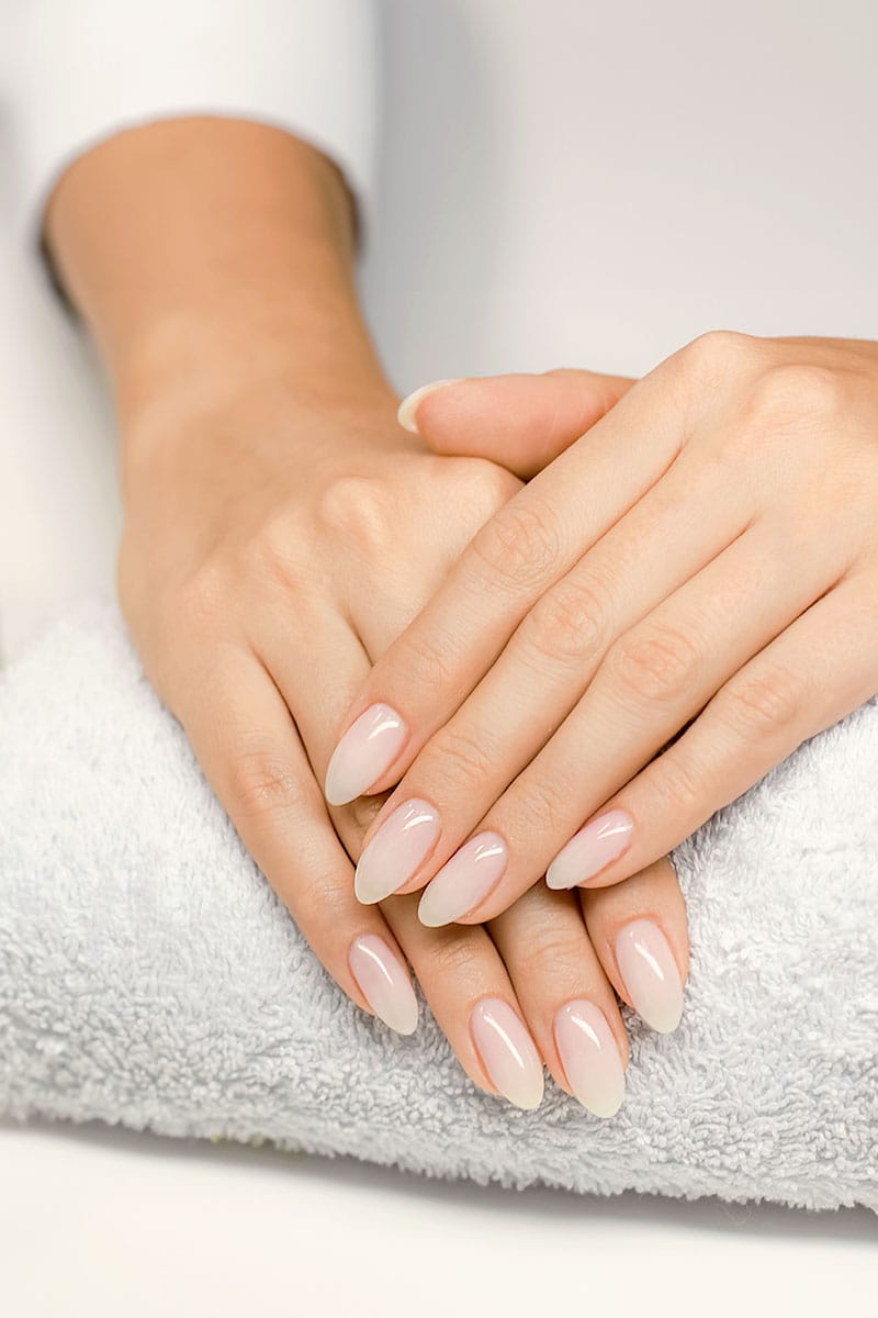 Gepflegte Hände liegen entspannt auf einem weißen Handtuch nach einer luxuriösen Maniküre im Hotel Kaiserhof Heringsdorf.