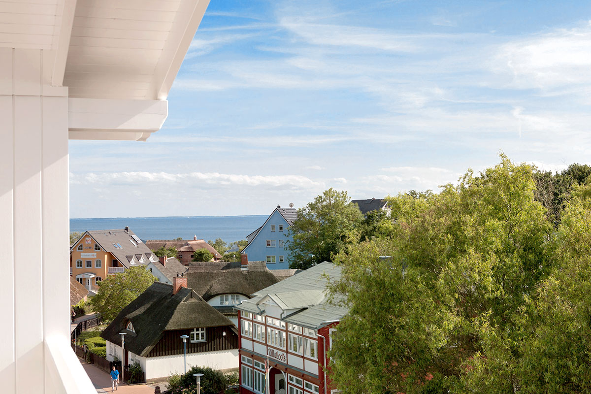 View from Koopmanns Hotel over colorful houses and thatched roofs to the Baltic Sea during the Summer Special