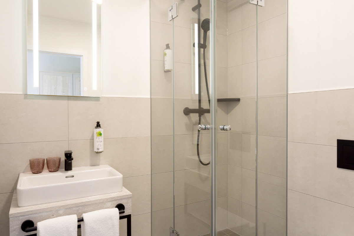 Modern bathroom with shower, washbasin and elegant furnishings in the double room of the Koopmanns Hotel.