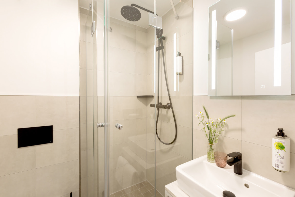 Elegant bathroom with glass shower and modern details in the double room at the Koopmanns Hotel &amp; Lädchen.