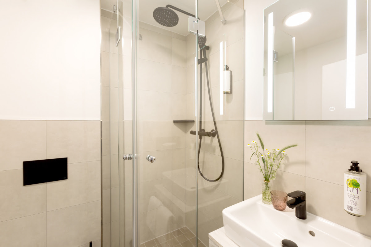 Modern bathroom with large shower, illuminated mirror and wash area in the double room of the Koopmanns Hotel.