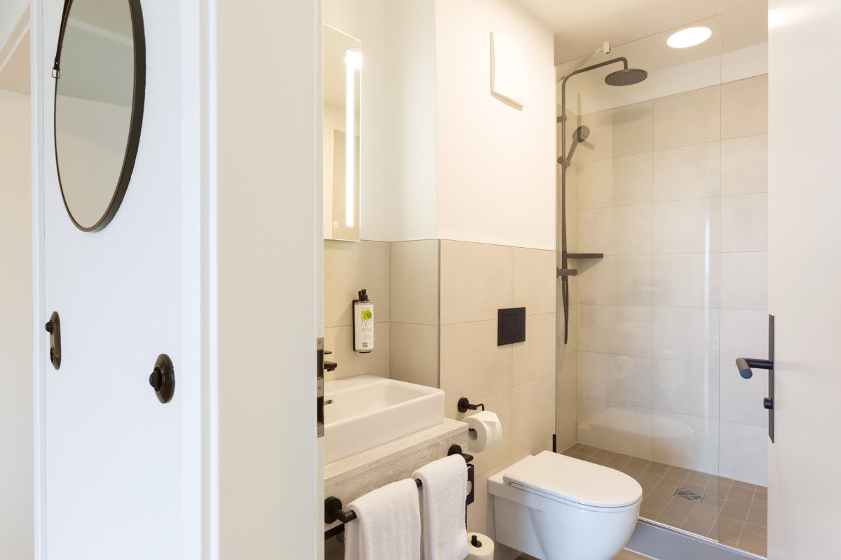Functional and stylish bathroom with shower, WC and mirror in the comfort double room at the Koopmanns Hotel.