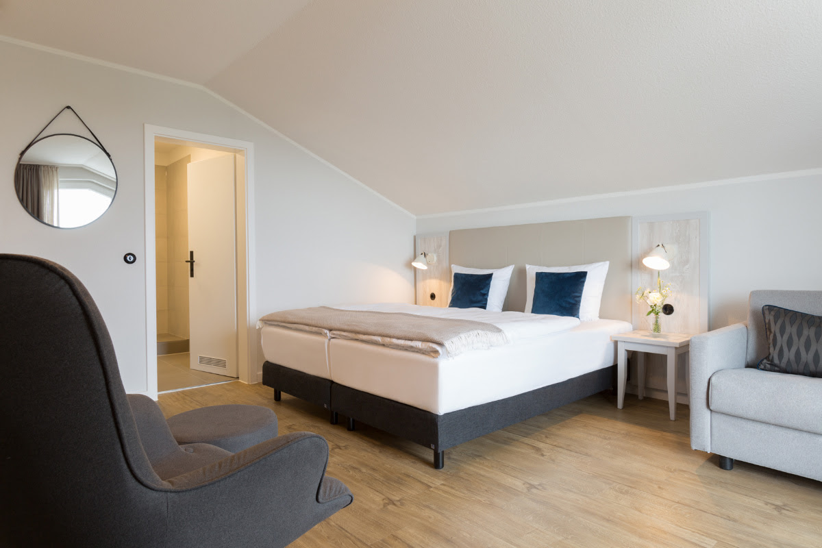Spacious comfort room with balcony and elegant furnishings for pure relaxation at the Koopmanns Hotel on Rügen.