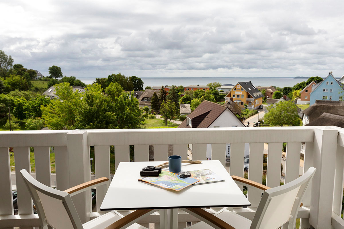 Balcony of the superior double room at Koopmanns Hotel with table, two chairs and view of the Baltic Sea and Göhren.