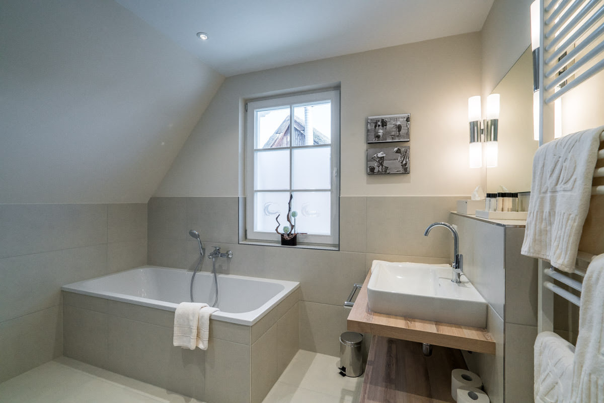 Modern bathroom with bathtub in the Seewind vacation home at Hotel Künstlerquartier Seezeichen.