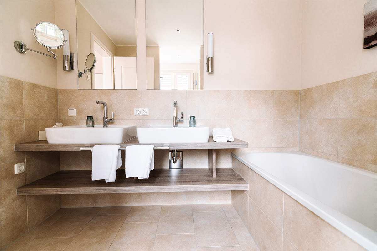 Modern bathroom in the Seeigel vacation apartment in the Seezeichen artists' quarter with double washbasin and bathtub.