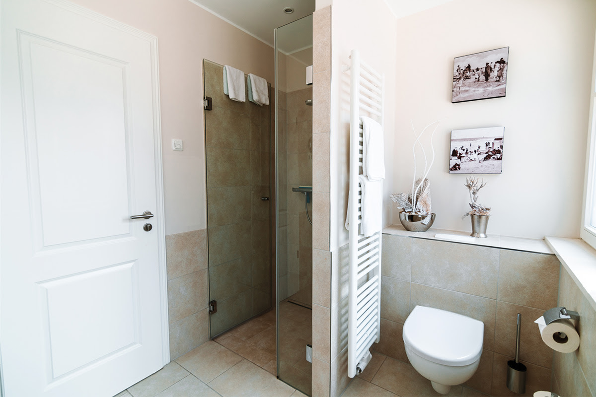 Bright bathroom with glass shower in the Strandmuschel vacation apartment in the Hotel Künstlerquartier Seezeichen.