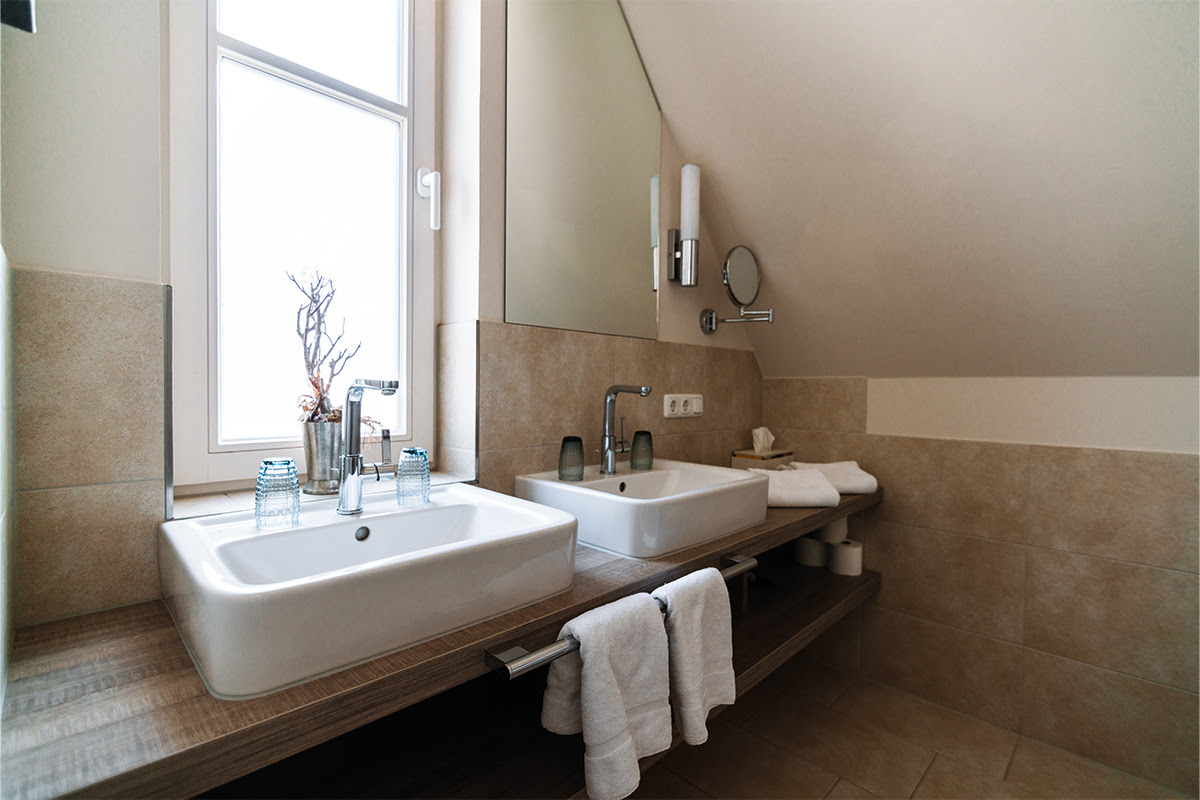 Elegant bathroom with double washbasin and daylight in the Strandnixe vacation apartment in the Ahrenshoop dune park.