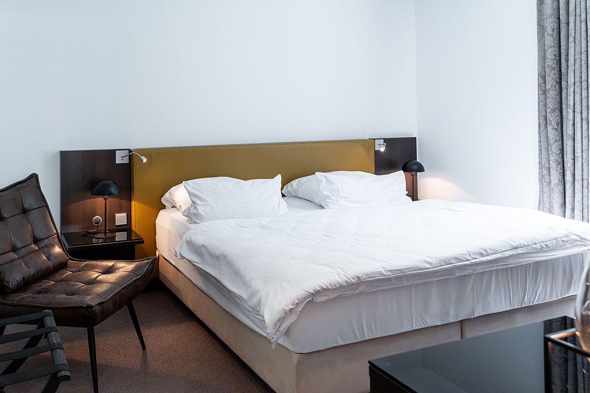 Modern bedroom with large double bed in the Seeschwalbe vacation apartment in the Hotel Künstlerquartier Seezeichen.