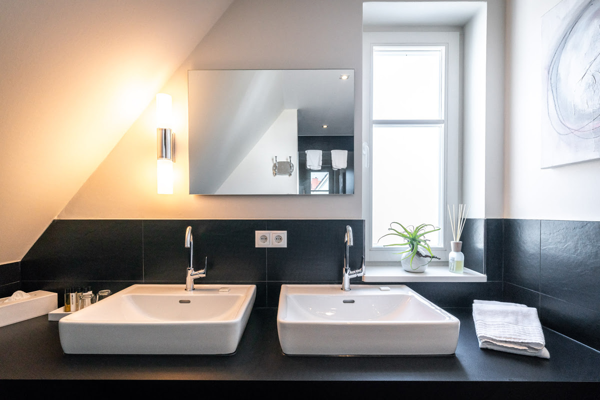 Modern bathroom with double washbasin and daylight in the Strandjuwel vacation apartment in the Hotel Künstlerquartier Seezeichen.