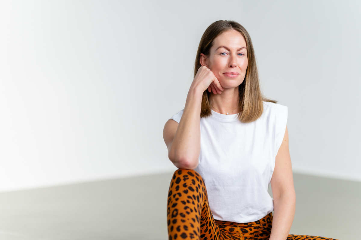 Porträt von Yogalehrerin Anne Kunstmann, lächelnd in sportlicher Kleidung bereit für das Yoga Retreat im Vju Hotel.