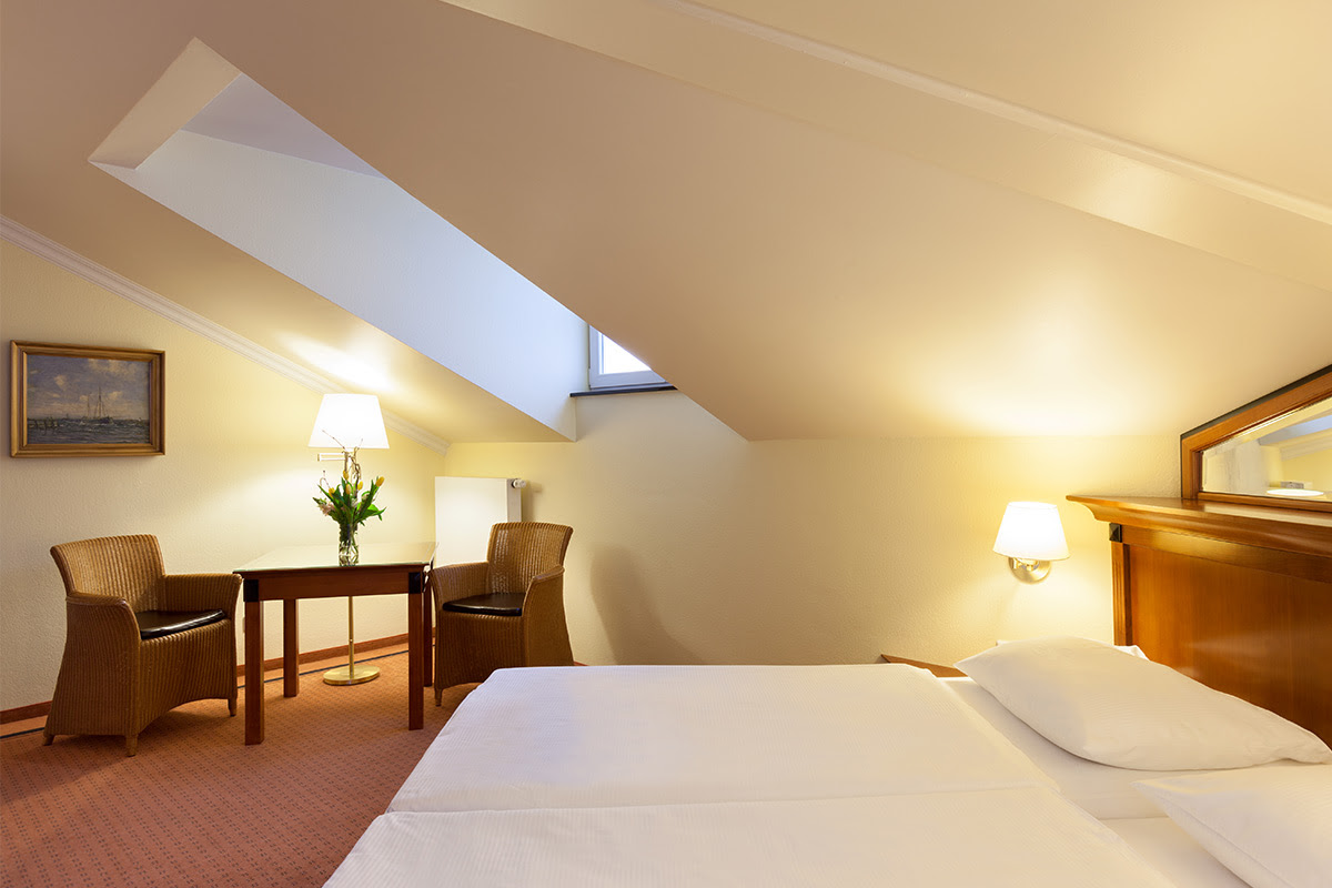 Comfortable hotel room in the annexes of the Vju Hotel with cozy double bed, skylight and seating area.